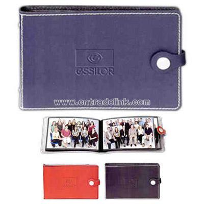 Leather photo album with decorative stitching and snap closure